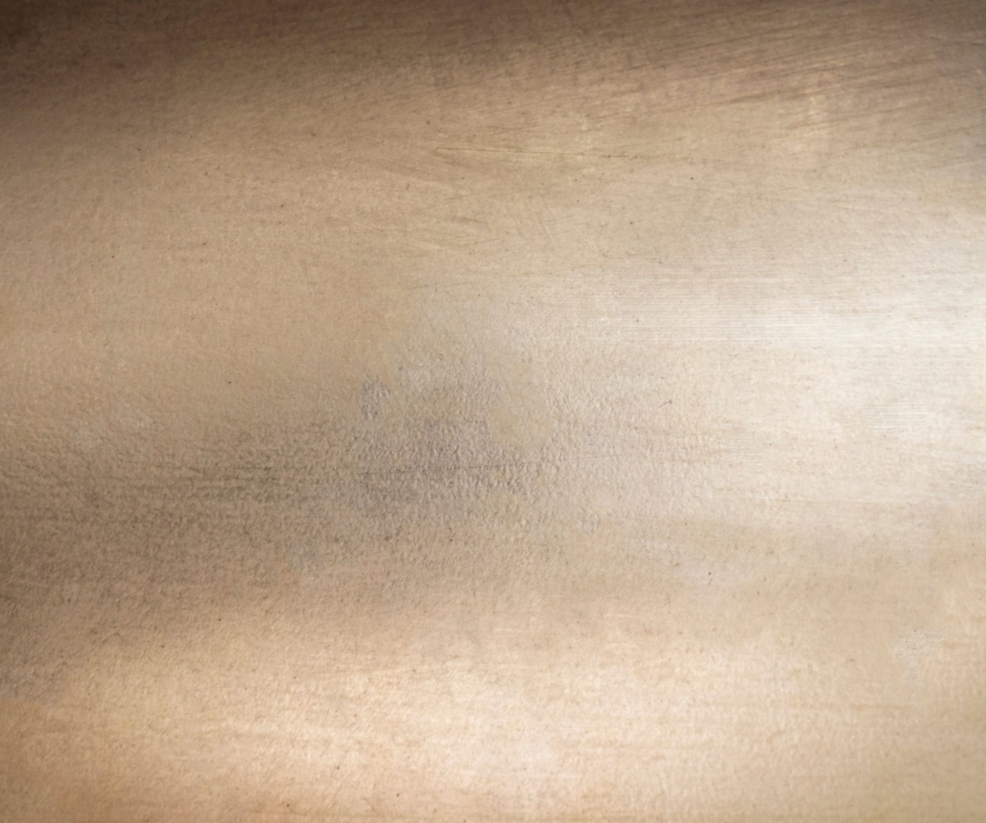 Textured metallic surface with subtle color variations.