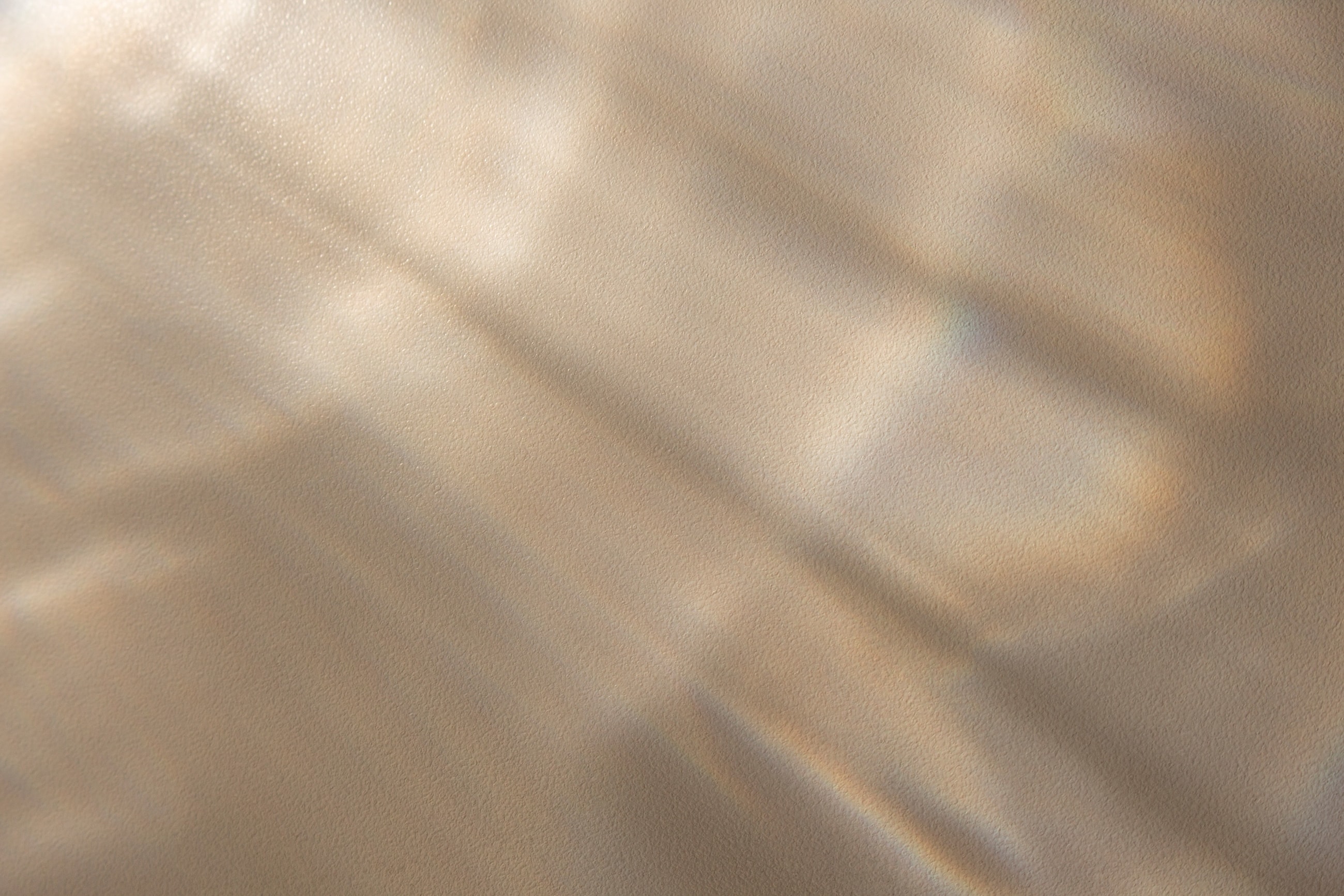 Soft beige fabric with subtle light reflections.