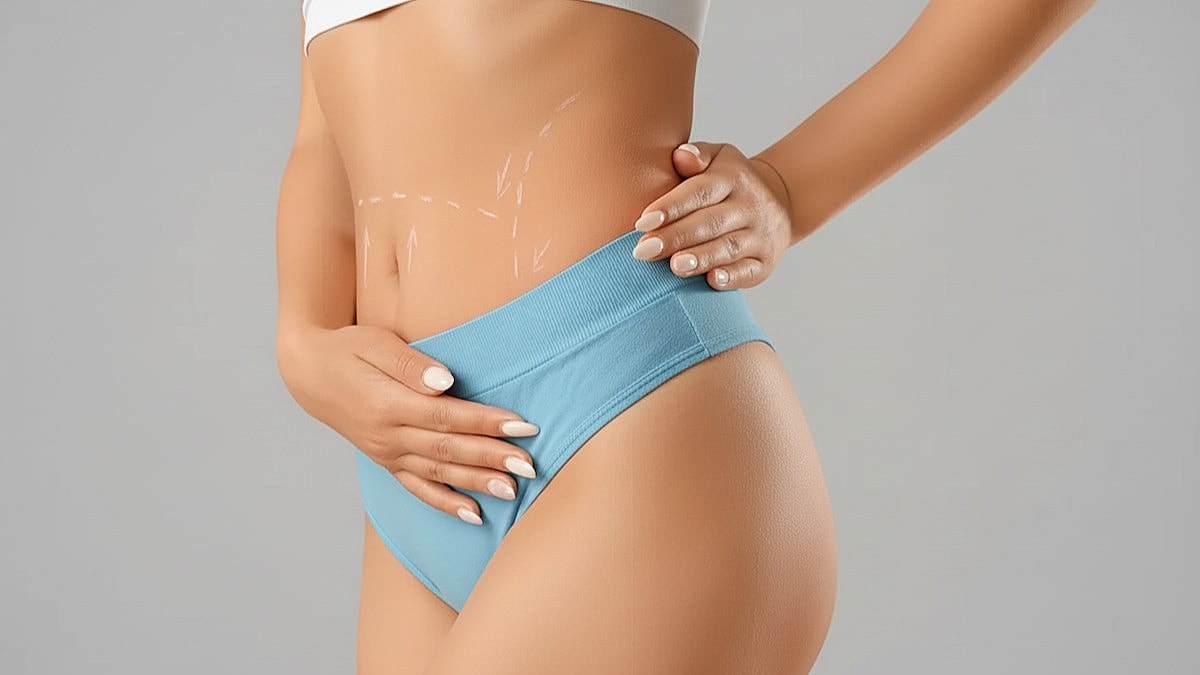 Tummy Tuck Cost in Houston TX Blog Image by Dr Ravi - Woman in blue underwear touching stomach area.