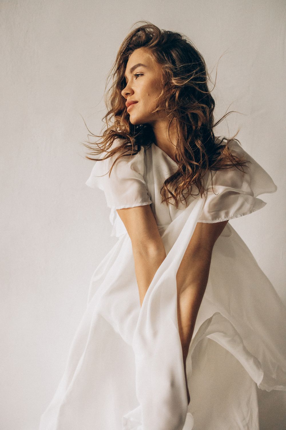 Houston mini neck lift model in flowing white dress against light background