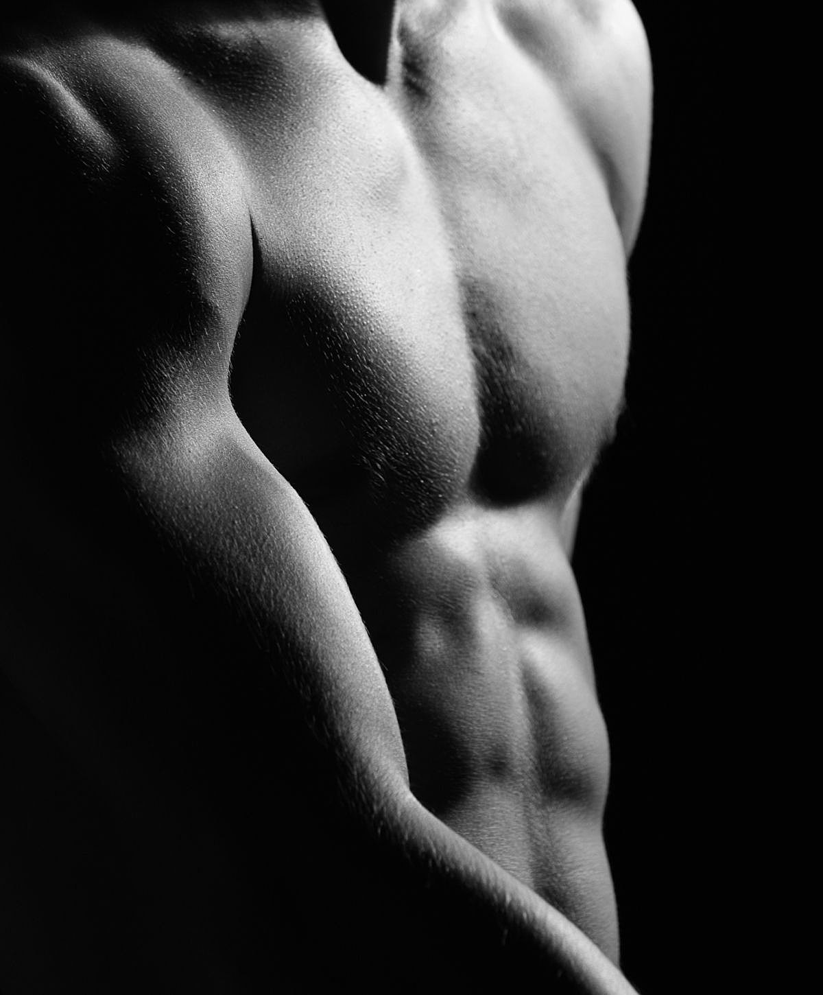 Houston Gynecomastia Surgery model's torso in dramatic black and white lighting.