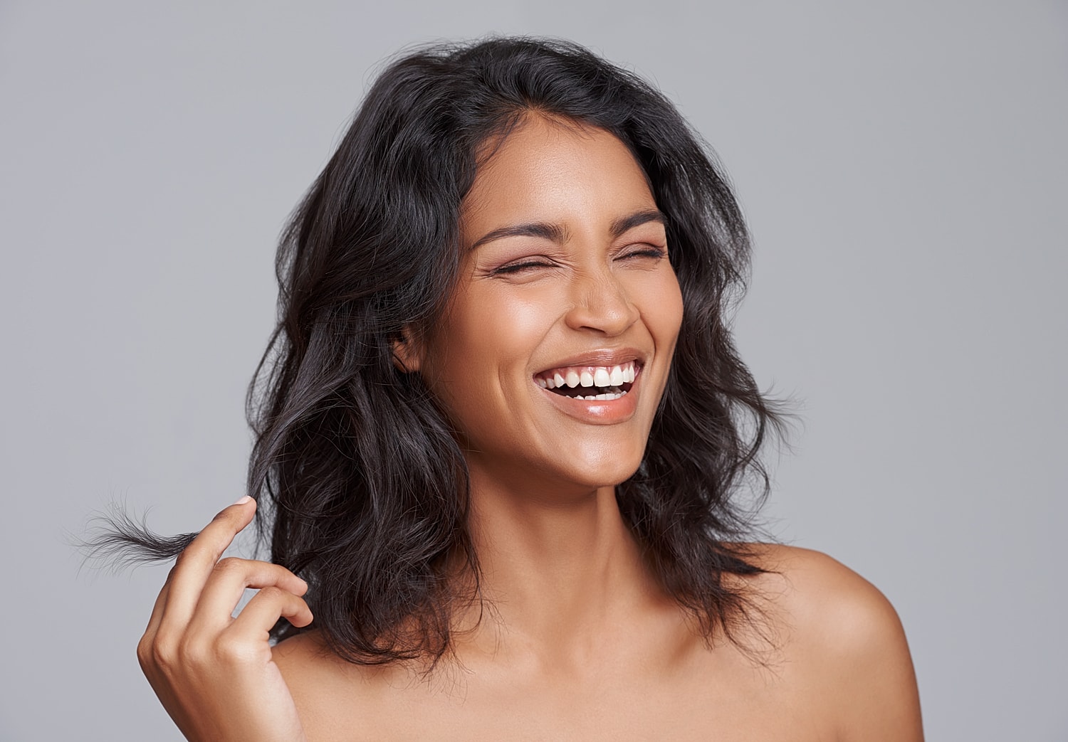 Smiling woman touching her hair, natural beauty.