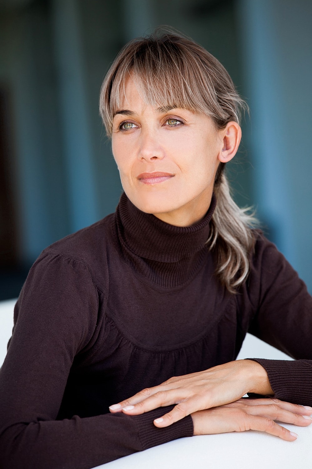 Thoughtful woman in a brown turtleneck sweater.