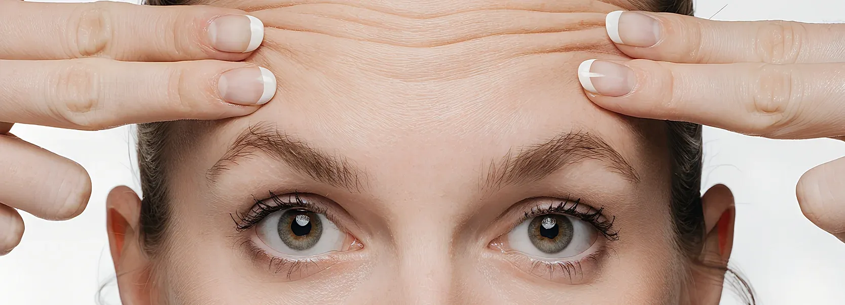Woman touching forehead with visible wrinkles.