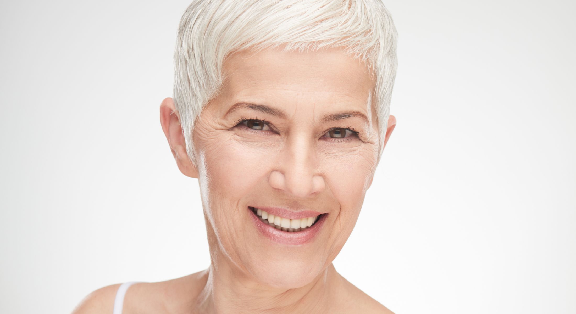 Smiling older Houston deep plane facelift model with short gray hair