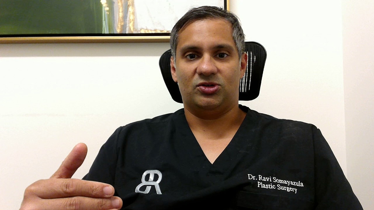 Doctor discussing plastic surgery in consultation setting.